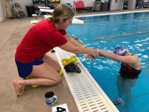 Coach teaching swimming skills.